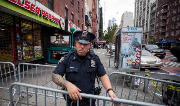 A New York City Police Department officer places barricades near the site of Saturday night's explosion in Chelsea