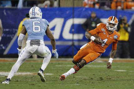 Clemson quarterback Deshaun Watson runs the ball as North Carolina's M.J. Stewart moves in for the tackle during the first half of the Atlantic Coast Conference championship NCAA college foot