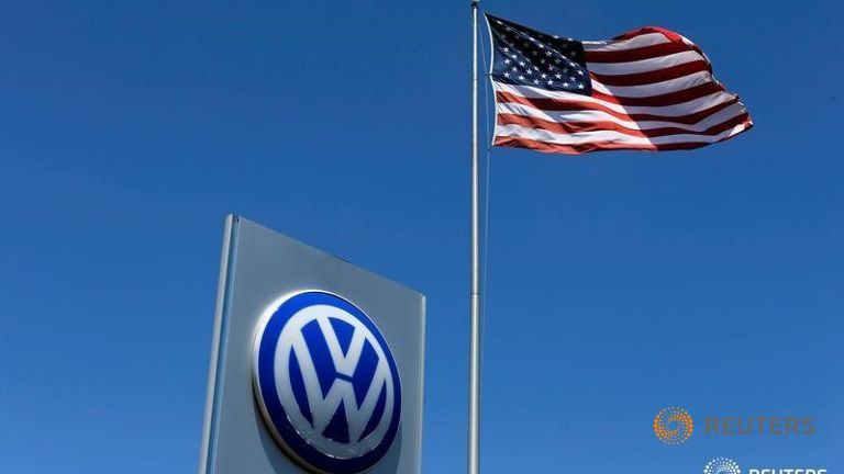 A U.S. flag flutters in the wind above a Volkswagen dealership in Carlsbad California