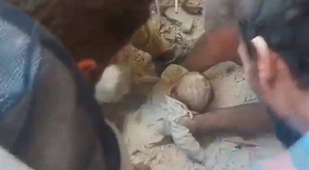 A baby is rescued from the rubble of a collapsed building in Aleppo in a still image taken from a video posted on social media