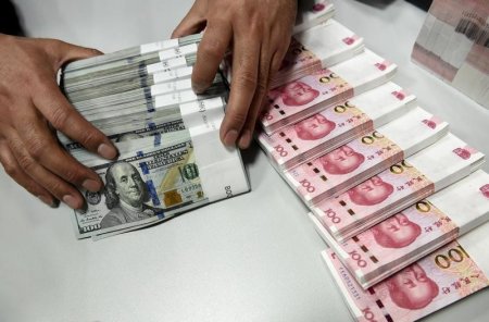 A clerk counts Chinese yuan and U.S. dollar banknotes at a branch of Bank of China in Taiyuan Shanxi province China