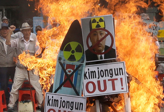 A defaced image of North Korean leader Kim Jong Un was burned by protesters Saturday during a rally in Seoul South Korea. Click