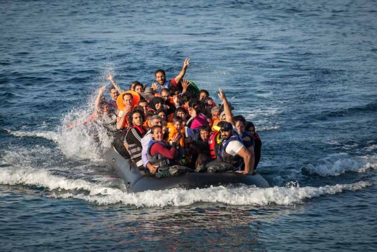 A dinghy carrying refugees arrives at a beach on the island of Lesbos in northern Greece