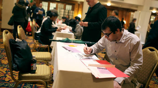 A job seeker fills out an application at a job fair in San Francisco California