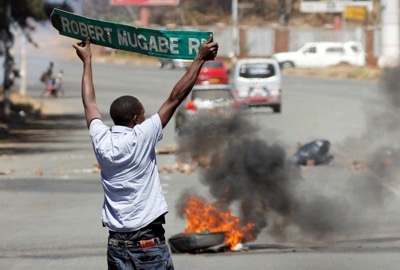 A man carries a street sign as opposition party supporters clash with police in Harare Zimbabwe August 26,2016. REUTERS  Philimon Bulawayo