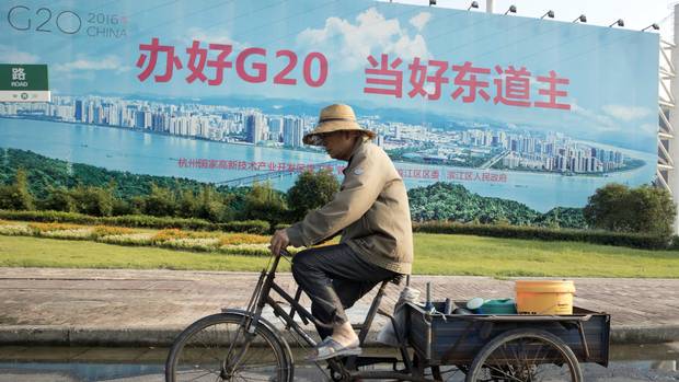 A man cycles past a propaganda board about the G20 in Hangzhou in eastern China's Zhejiang province