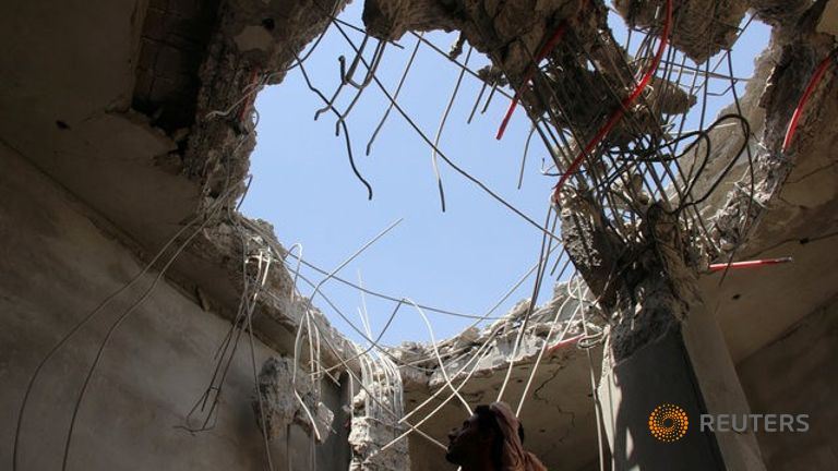 A man looks at a hole caused by a Saudi-led air strike on a building in the northwestern city of Saada Yemen