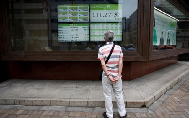 A man looks at an electronic board showing the Japanese yen's exchange rate against Euro outside a brokerage in Tokyo Japan