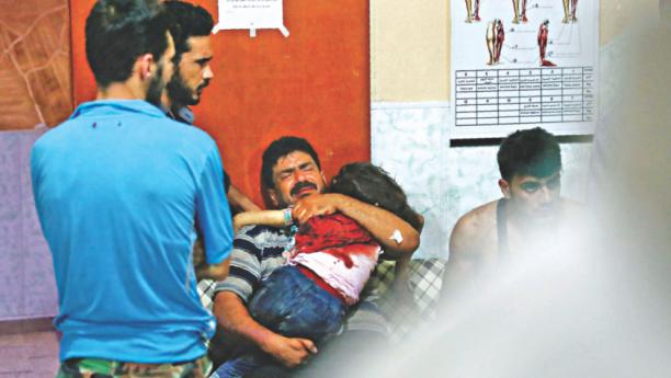 A man mourns and holds his daughter after she succumbed to her injuries