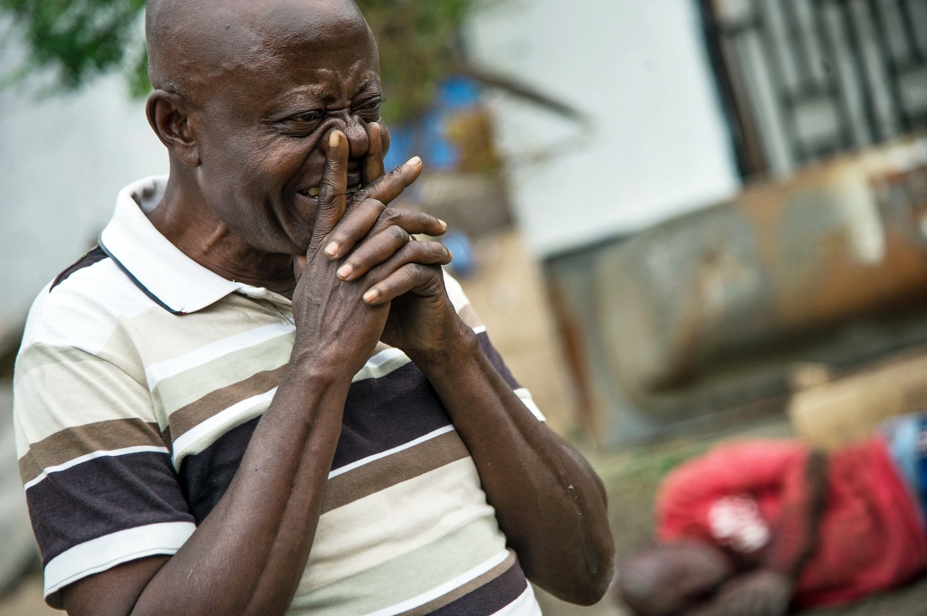 A man weeps near one of the opposition party offices set ablaze overnight in KinshasaJUNIOR