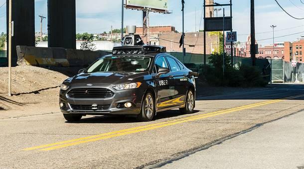 A passenger look on as he rides in a pilot model of an Uber self-driving car in Pittsburgh Pennsylvania.
   Marketplace