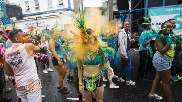 A performer has powder paint thrown at her face at the Notting Hill Carnival in London England