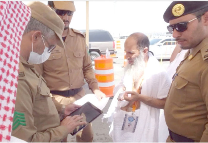 A pilgrim's papers being electronically checked at a checkpoint. — Courtesy Makkah newspaper