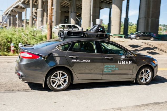 A pilot model of an Uber self-driving car goes down a street in Pittsburgh Pennsylvania