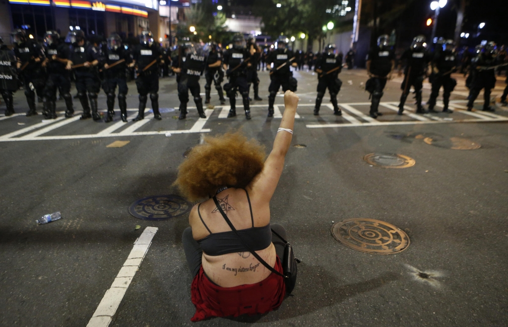 A protester demonstrates against the death of Keith Scott in front of police in Charlotte N.C. on Wednesday