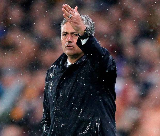 A rain-soaked United manager Jose Mourinho gestures during the game