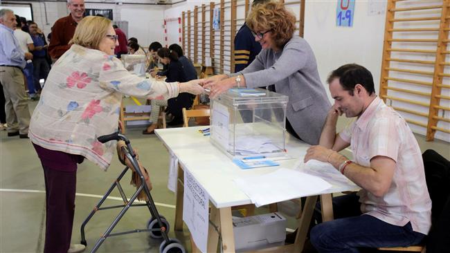 A woman casts her vote at a polling station during regional parliamentary elections in Vigo northern Spain