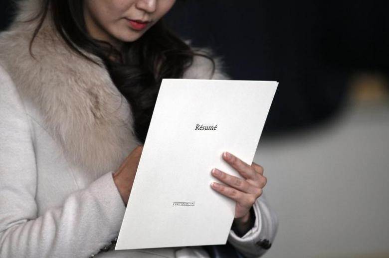 A woman clutches her resume at the Colorado Hospital Association health care career fair in Denver