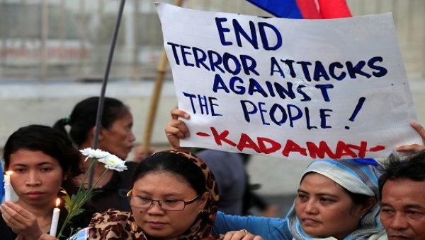 A woman holds a placard condemning the bombing at a market in Davao city Manila Philippines