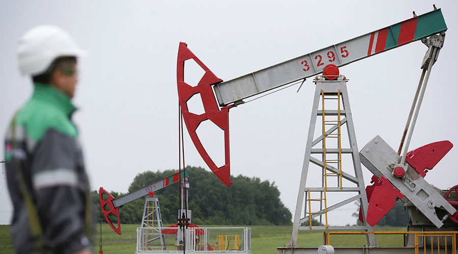 A worker at a pump jack at an oil field owned by Bashneft company north from Ufa Russia