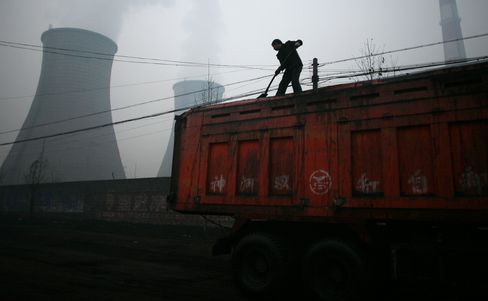 A worker shovels coal near a power plant in Linfen China