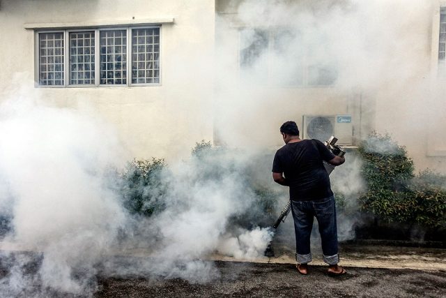 A worker sprays pesticide at an apartment block in Kuala Lumpur Malaysia