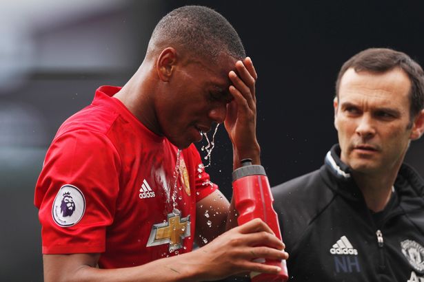 Anthony Martial pours water on his face after being hurt in a challenge