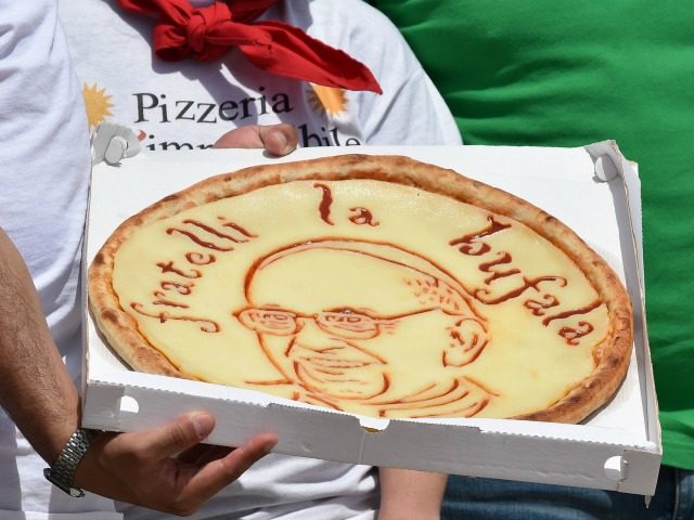 A pizza maker waits to show his pizza with a drawing of Pope Francis at the end of his weekly general audience at St Peter's square