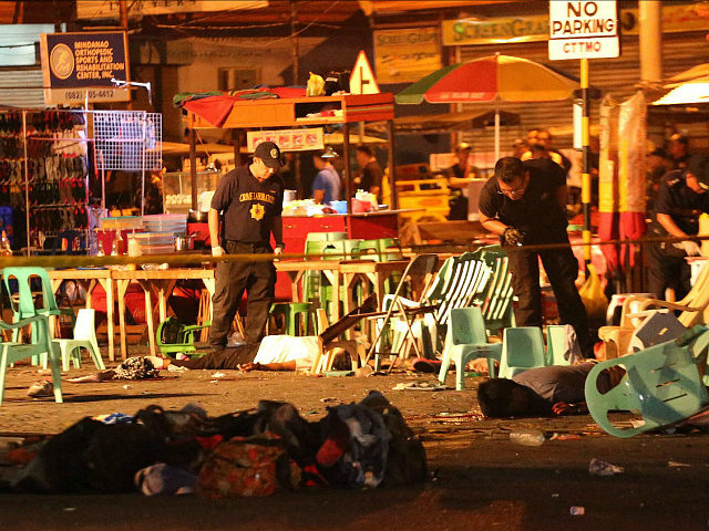 Philippine police officers look at dead victims after an explosion at a night market that has left about 10 people dead and wounded several others in southern Davao city Philippines late Friday Sept. 2 2016. Regional military commander Lt. Gen. Rey Leon