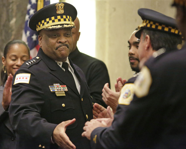 Chicago's police superintendent Eddie Johnson left shakes hands with other officers at a city council meeting