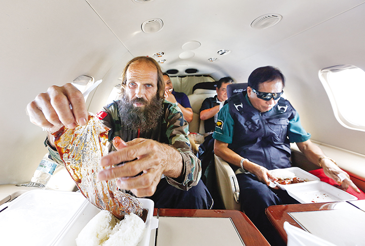 TASTE OF FREEDOM – Norwegian Kjartan Sekkingstad is treated to a packed meal consisting of rice and chicken adobo on the flight to Davao City with Presidential Adviser on the Peace Process Jesus Dureza after his release from his Abu Say