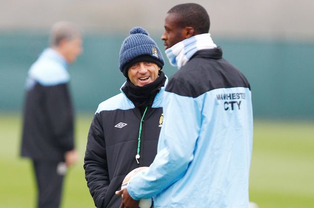 Manchester City manager Roberto Mancini and Yaya Toure during training