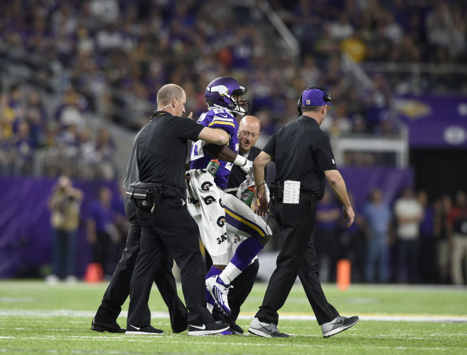 Adrian Peterson is carried off the field by trainers in the third quarter Sunday after injuring his knee