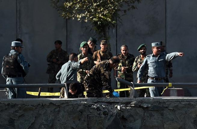 Afghan police examine the site of two suicide bombings in Kabul