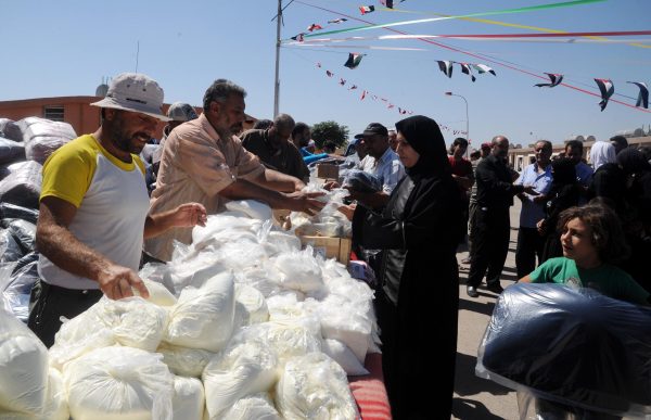 Aid has reached some displaced Syrians near the capital Damascus but all convoys to the besieged Aleppo have been suspended