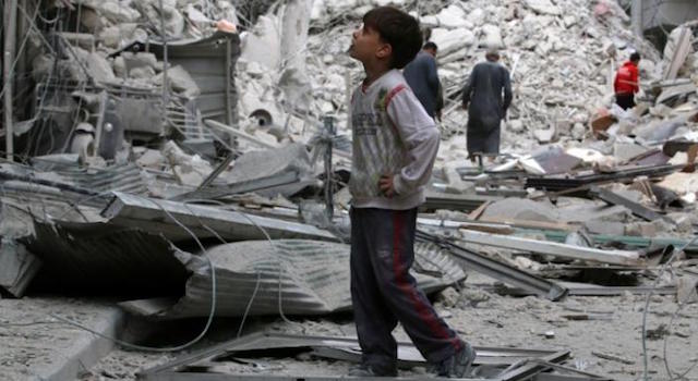 A boy inspects a damaged site after airstrikes on the rebel held Tariq al Bab neighbourhood of Aleppo Syria