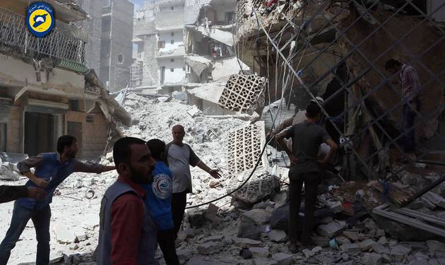 Syrian Civil Defense White Helmets men stand amid rubble after airstrikes in al Mashhad neighborhood in the rebel-held part of eastern Aleppo Syria Wednesday Sept. 21 2016. Ibrahim Alhaj a member of the volunteer first