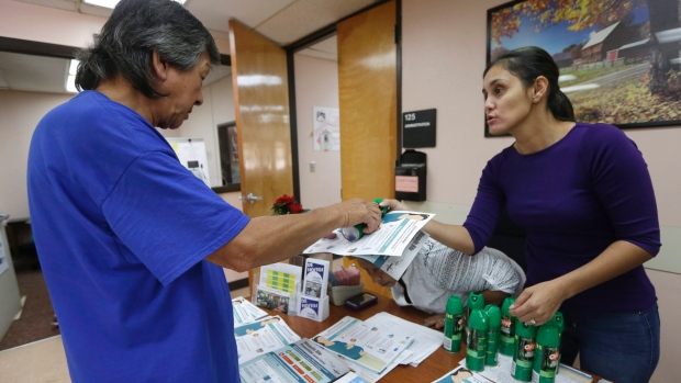 A community worker at the Wynwood Community Service Center right hands out insect repellent in Miami. Orlando's major theme parks will also offer free bug repellent to visitors as a precaution against Zika infection