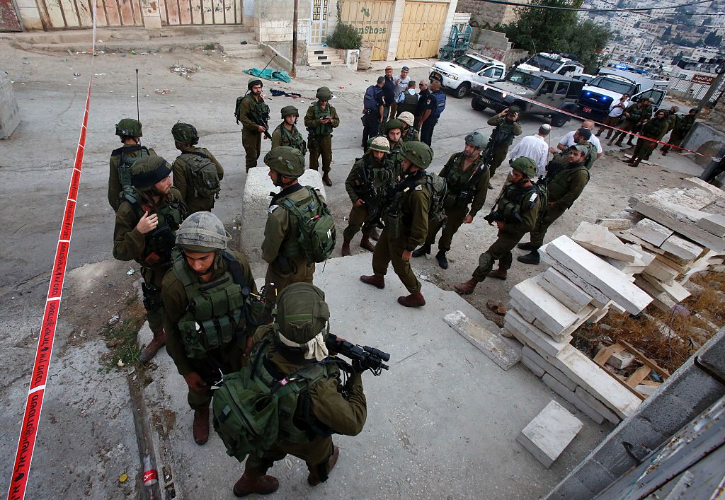 Israeli security forces gather at the scene of a stabbing attack where a Palestinian stabbed an Israeli soldier before he was shot dead in the flashpoint West Bank city of Hebron on Sept. 17 2016