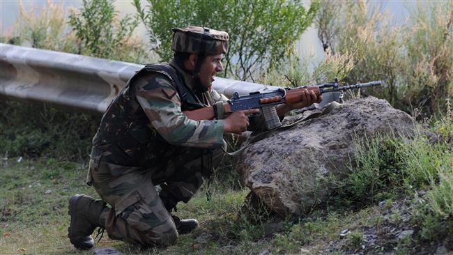 An Indian army soldier takes up a position near the border with Pakistan in Uri