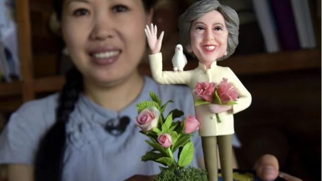 An artist shows a clay figure of British Prime Minister Theresa May to mark the G20 summit