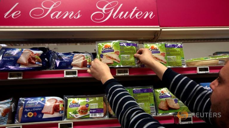 An employee arranges gluten-free products in a supermarket in Nice France