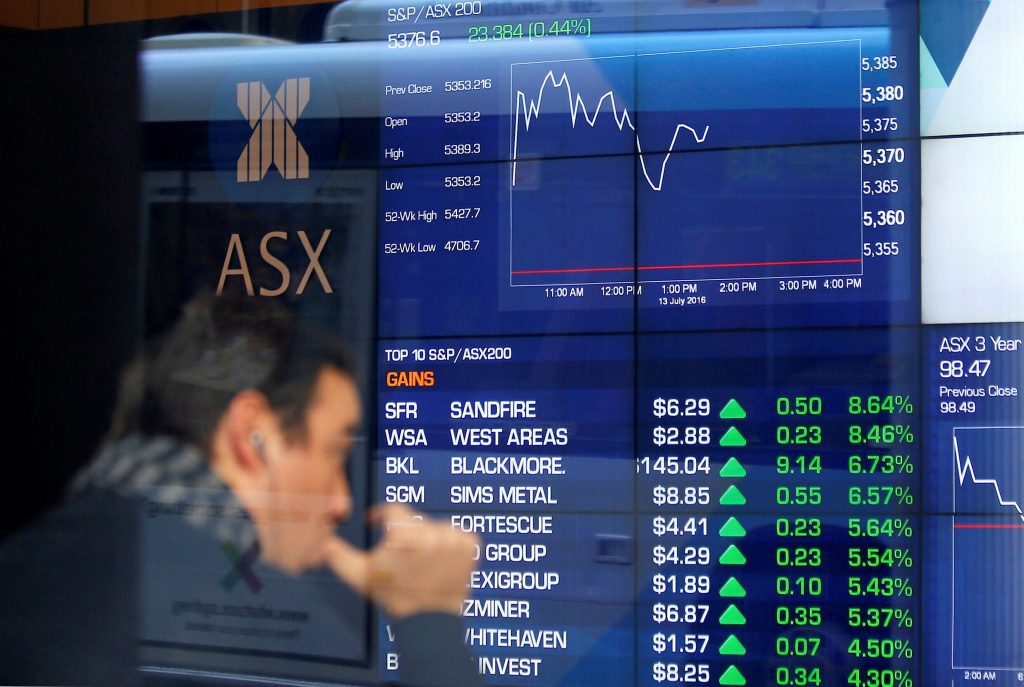 An investor reacts as he looks at a board displaying stock prices at the Australian Securities Exchange in Sydney Australia