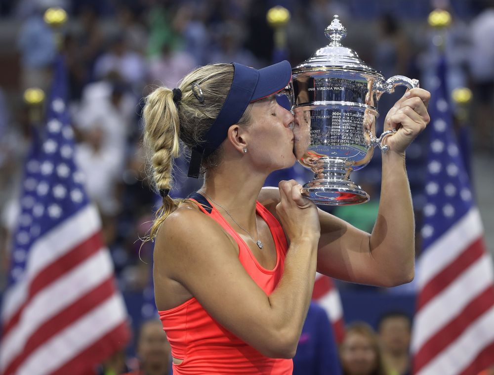 Angelique Kerber of Germany kisses the championship trophy after beating Karolina Pliskova of the Czech Republic to win the women's singles final of the U.S. Open tennis tournament Saturday Sept. 10 2016 in New York