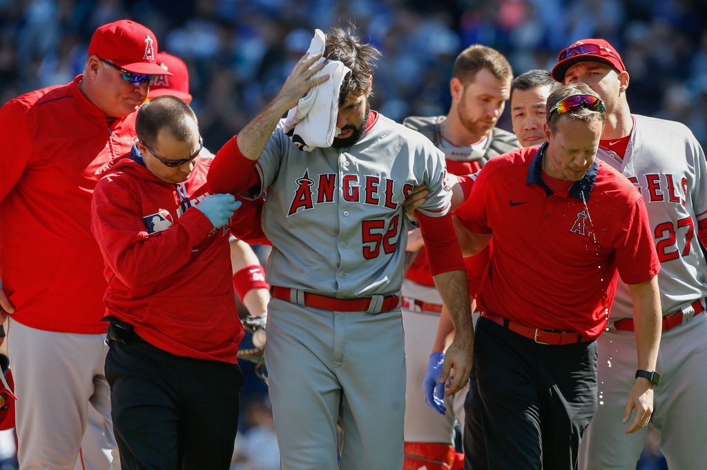 SEATTLE WA- SEPTEMBER 04 Starting pitcher Matt Shoemaker #52 of the Los Angeles Angels of Anaheim is helped off the field after being hit in the head with a batted ball off the bat of Kyle Seager of the Seattle Mariners in the second inning at Safeco