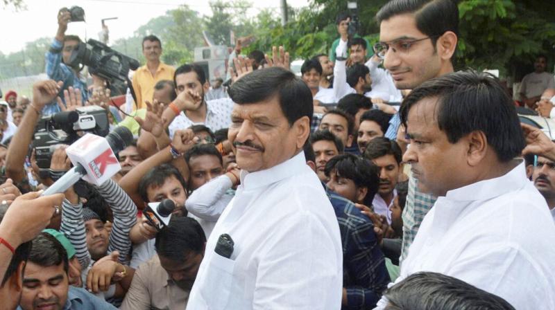 SP leader Shivpal Yadav along with his son Aditya Yadav and Gayatri Prajapati, addresses supporters outside his residence in Lucknow