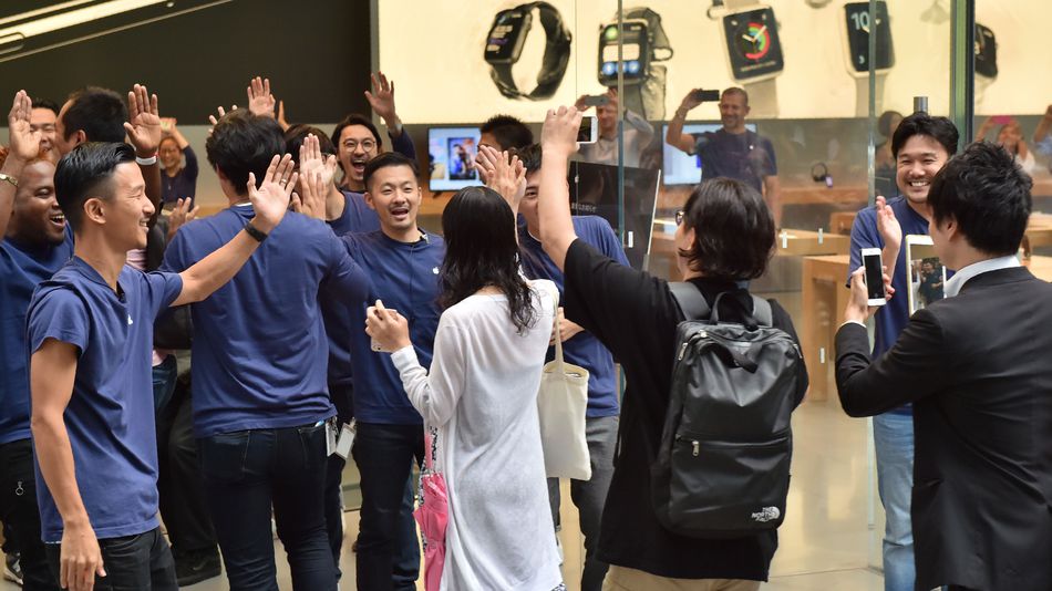 Apple employees greet customers as they arrive to buy the new Apple iPhone 7 at the company's flagship store in Tokyo