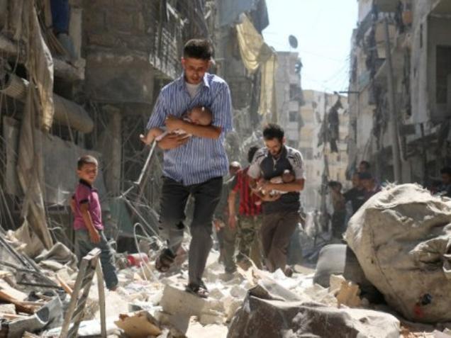 Syrian men carrying babies make their way through the rubble of destroyed buildings following a reported air strike on the rebel-held Salihin neighbourhood of the northern city of Aleppo