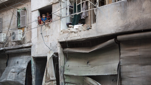 Syrian children look at the damage following an airstrike in Aleppo's rebel-controlled neighbourhood of Karm al Jabal on Sunday. On Monday an aid convoy was hit in a rural western area of Aleppo province