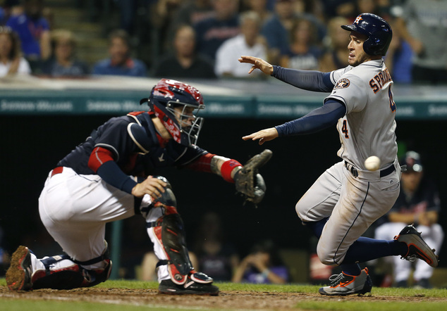 Houston Astros George Springer scores past Cleveland Indians catcher Roberto Perez on a sacrifice fly by Yulieski Gurriel during the seventh inning